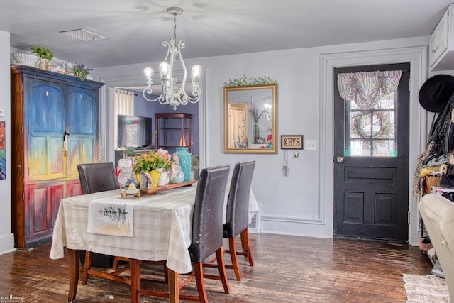 dining area featuring a chandelier and dark hardwood / wood-style flooring