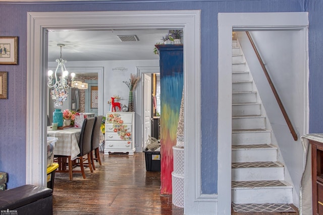 stairs featuring a chandelier and hardwood / wood-style floors