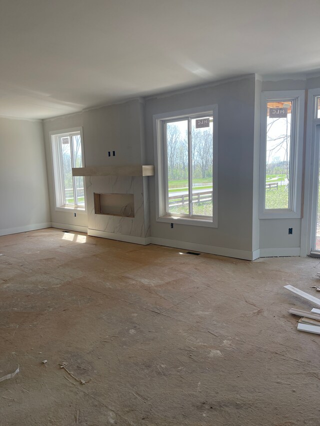 unfurnished living room featuring visible vents, baseboards, and a fireplace