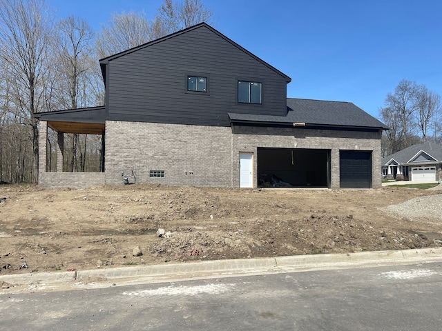view of side of property featuring brick siding and dirt driveway