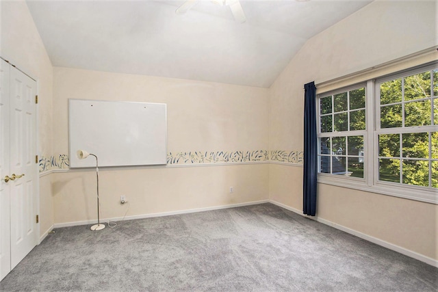 carpeted spare room featuring ceiling fan and lofted ceiling