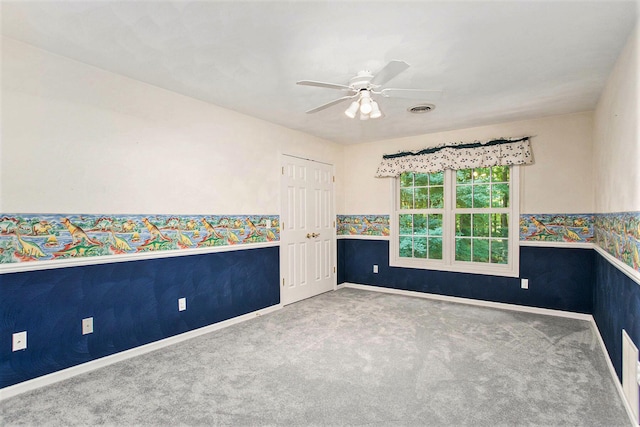 carpeted empty room featuring ceiling fan