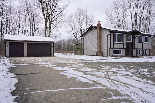 view of snow covered exterior with an outdoor structure and a garage