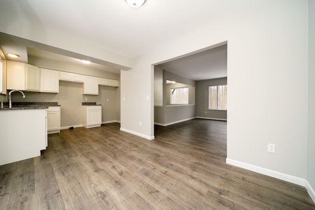 kitchen with sink, white cabinets, and light wood-type flooring