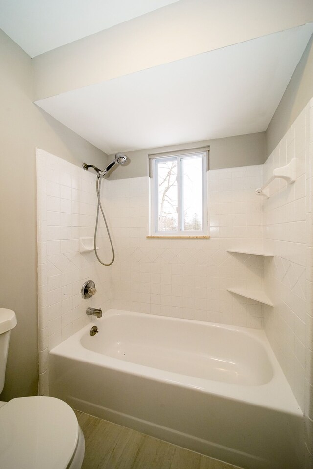 bathroom with shower / washtub combination, wood-type flooring, and toilet