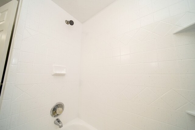 room details with tiled shower / bath combo