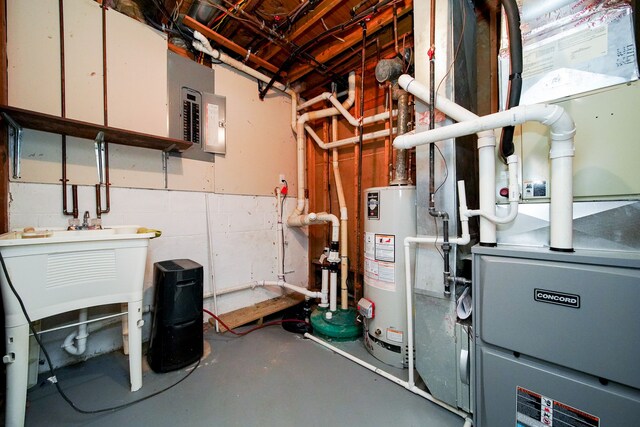 utility room featuring electric panel, sink, and gas water heater