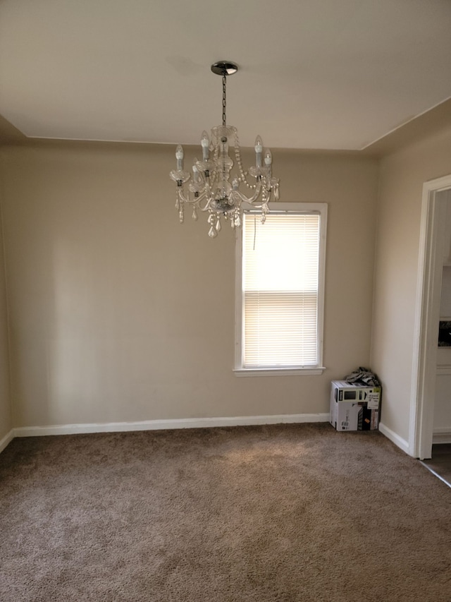 unfurnished room featuring a notable chandelier and dark colored carpet