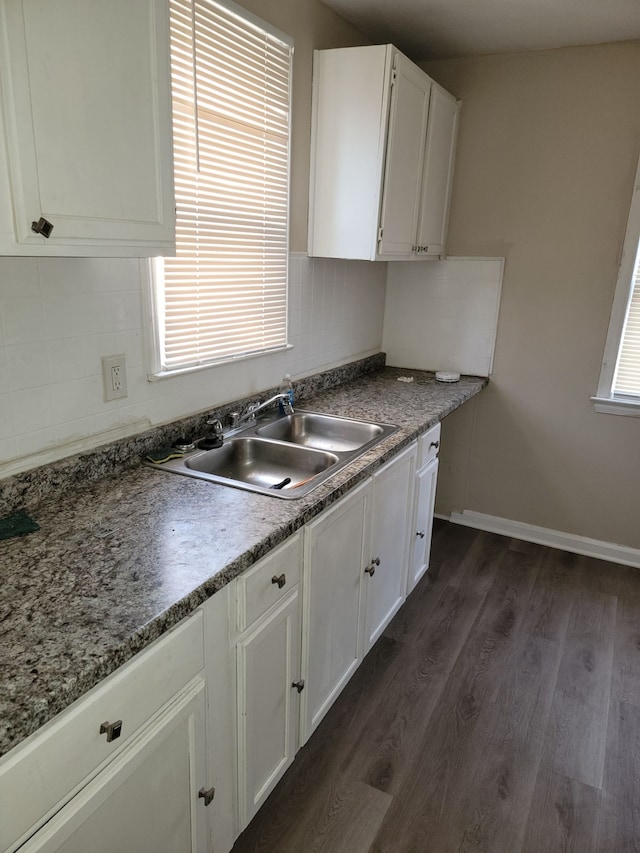 kitchen featuring dark wood-type flooring, a healthy amount of sunlight, sink, and white cabinets