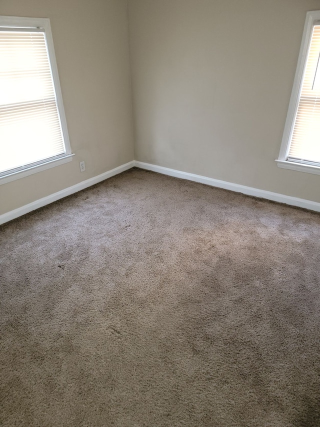 empty room with plenty of natural light and carpet