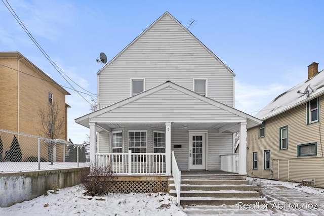 snow covered house featuring a porch