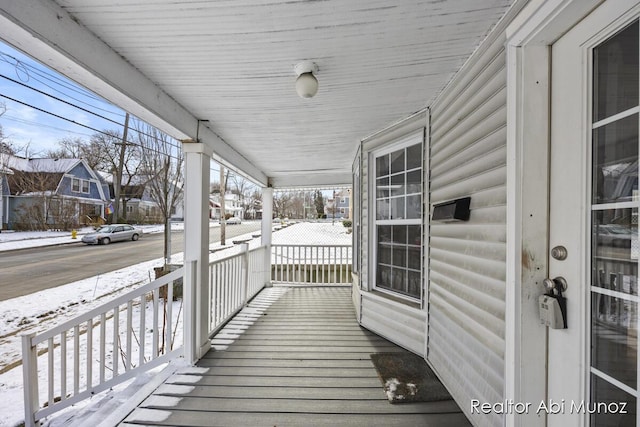 snow covered deck with covered porch