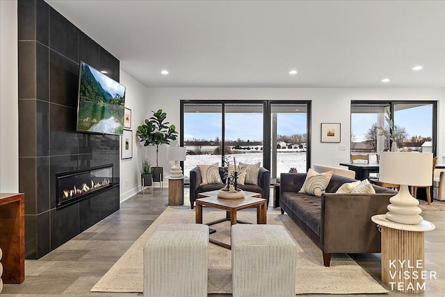 living room with a tile fireplace and hardwood / wood-style floors