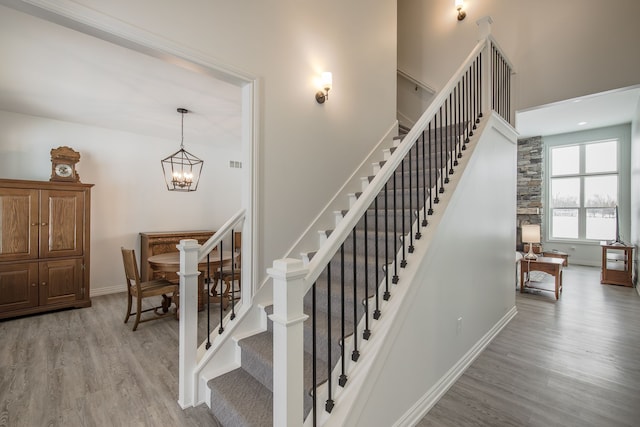 staircase with a chandelier and wood-type flooring