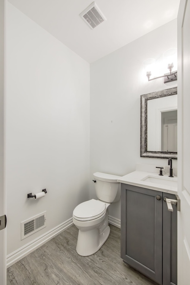 bathroom featuring hardwood / wood-style floors, vanity, and toilet