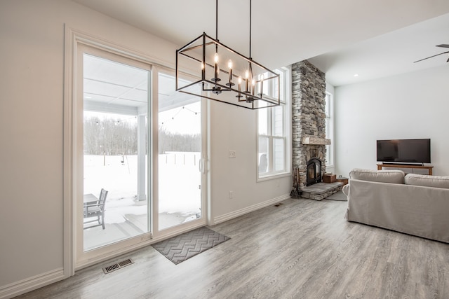 doorway to outside with ceiling fan with notable chandelier and hardwood / wood-style flooring