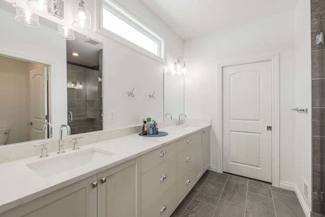 bathroom featuring tile patterned floors, vanity, toilet, and a shower with shower door