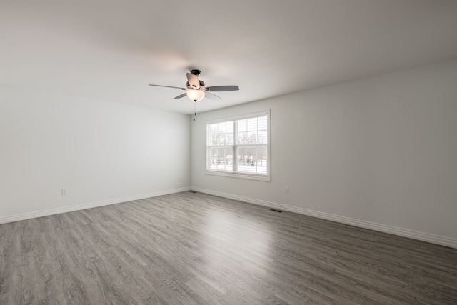 spare room featuring dark hardwood / wood-style floors and ceiling fan