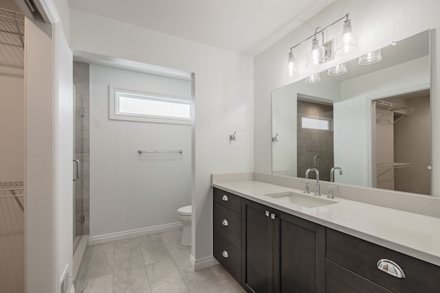 bathroom with an enclosed shower, vanity, and toilet