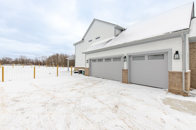 view of snow covered exterior featuring a garage