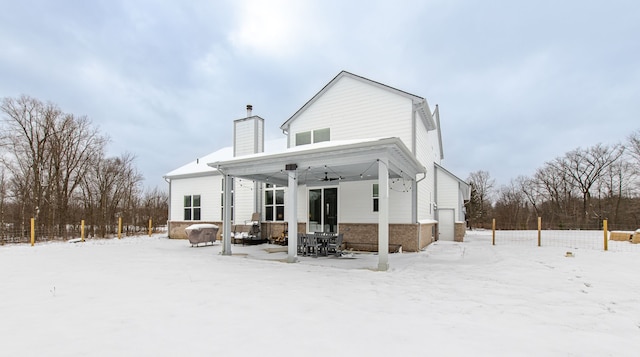 snow covered house featuring a garage