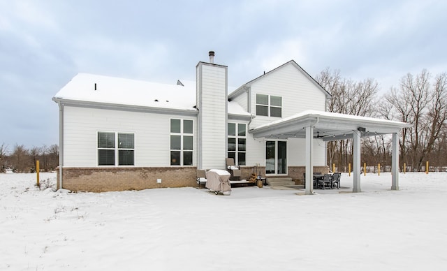 view of snow covered rear of property