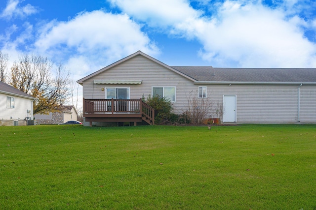 rear view of property with a yard and a deck