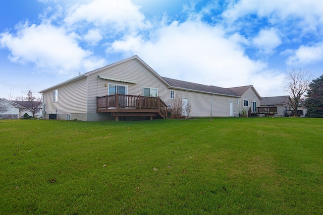 rear view of house featuring a yard and a wooden deck