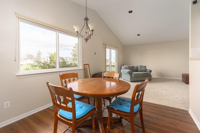 dining space with dark wood-type flooring, a wealth of natural light, and an inviting chandelier