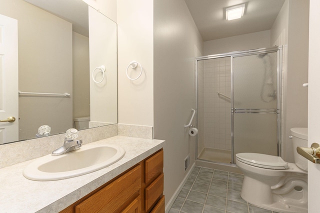 bathroom featuring tile patterned floors, vanity, a shower with shower door, and toilet