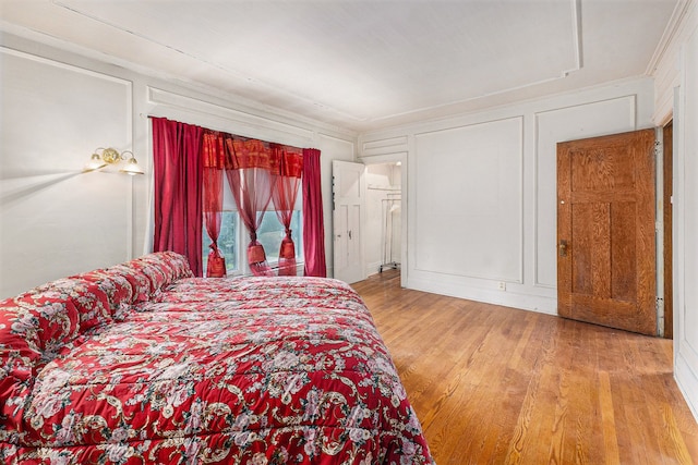 bedroom featuring wood-type flooring and crown molding