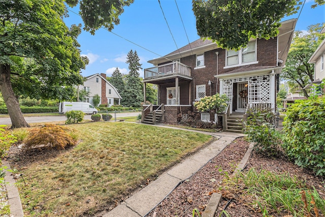 view of front of home featuring a front yard and a balcony