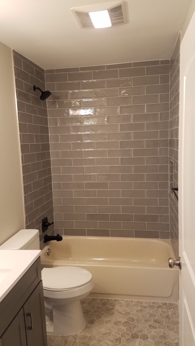 full bathroom with vanity, tiled shower / bath combo, and toilet