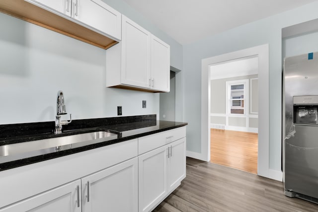 kitchen with sink, white cabinets, and stainless steel refrigerator with ice dispenser