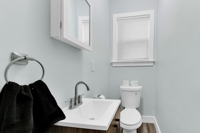 bathroom with hardwood / wood-style floors, vanity, and toilet