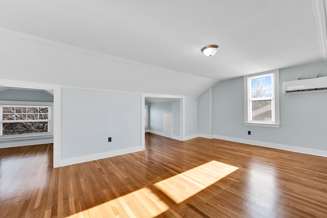 bonus room featuring a wall mounted air conditioner, hardwood / wood-style flooring, and vaulted ceiling