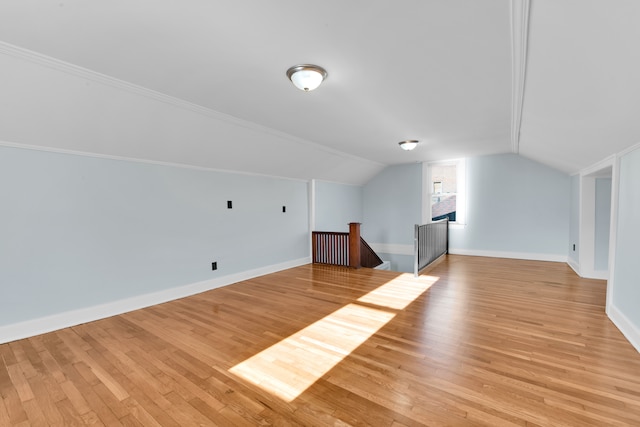 bonus room with light hardwood / wood-style flooring, lofted ceiling, and a brick fireplace