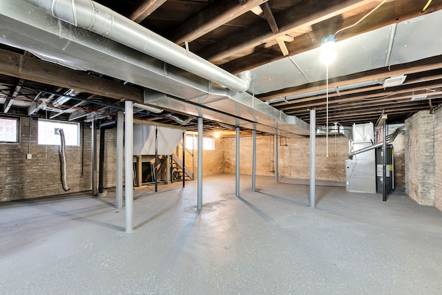 basement featuring brick wall and water heater