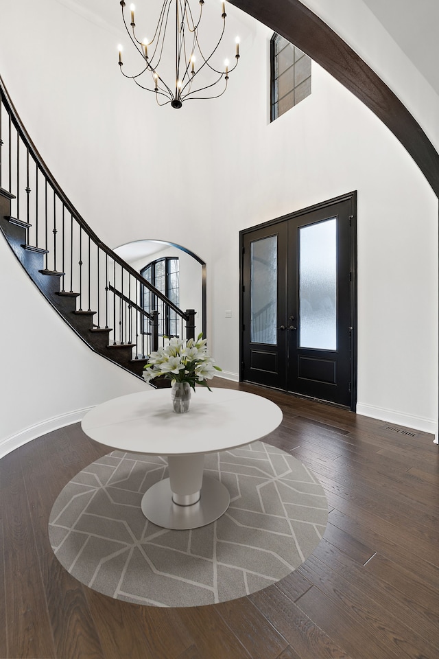 entryway featuring dark hardwood / wood-style flooring, french doors, and a towering ceiling