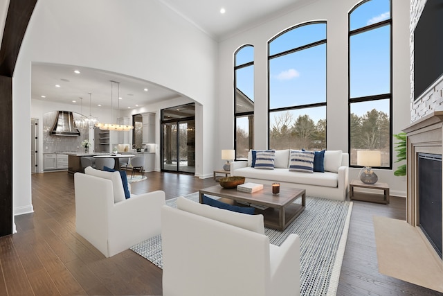 living room featuring a towering ceiling and dark wood-type flooring