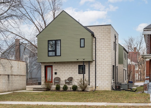 back of house featuring a lawn and central air condition unit