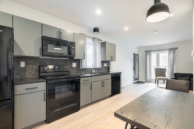 kitchen featuring decorative backsplash, sink, gray cabinets, and black appliances