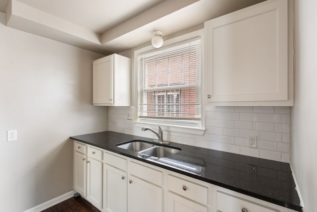 kitchen featuring white cabinets, tasteful backsplash, and sink