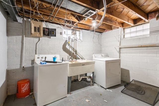 washroom with electric panel, washer and dryer, and sink