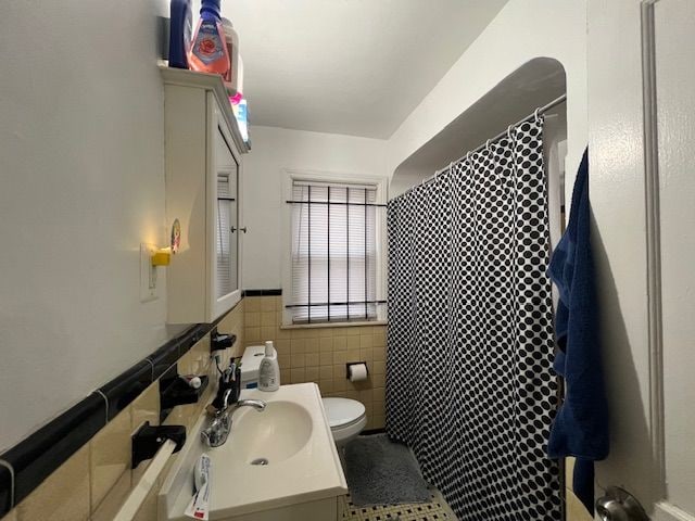 bathroom with vanity, a shower with shower curtain, tile walls, and toilet