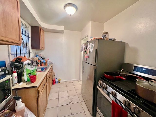 kitchen featuring stainless steel appliances and light tile patterned flooring