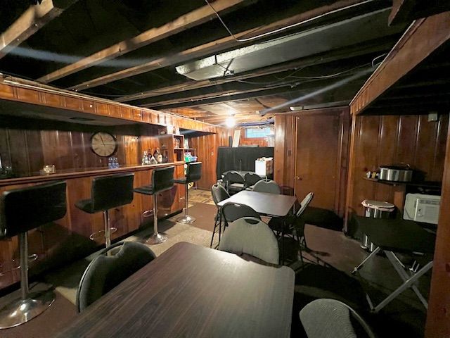 basement with indoor bar and wood walls