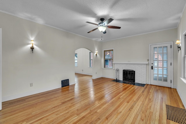 unfurnished living room featuring a healthy amount of sunlight, light wood-type flooring, and crown molding