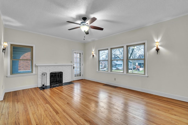 unfurnished living room with light hardwood / wood-style flooring, a healthy amount of sunlight, and a brick fireplace