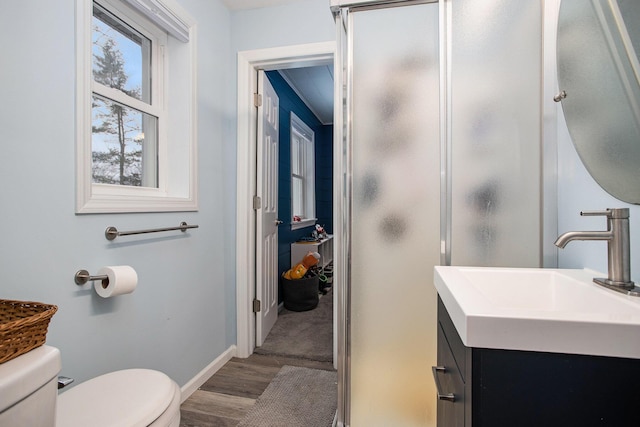 bathroom with sink, hardwood / wood-style floors, a shower with shower door, and toilet